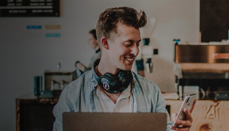 Man works on smartphone and laptop